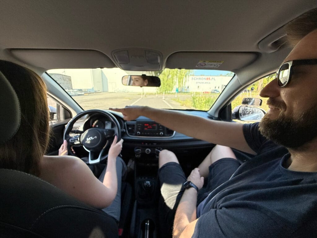 Instruktor szkoły jazdy w Koninie podczas nauki jazdy z kursantem w samochodzie
